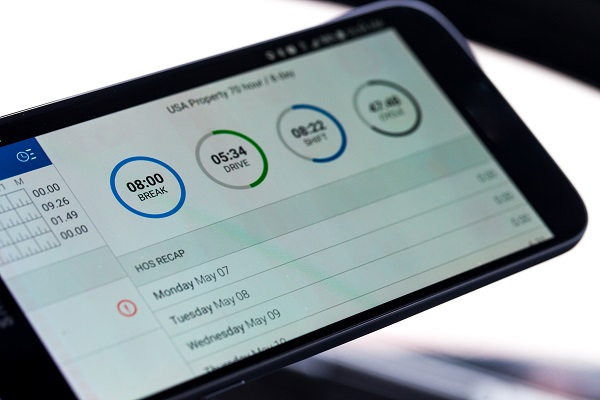 Close-up of an electronic logging device (ELD) screen displaying driving hours, break time, and shift details used for tracking commercial vehicle drivers' hours of service.