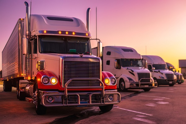 Parked semi-trucks at the rest area, on a vibrant sunset evening. (644277924)